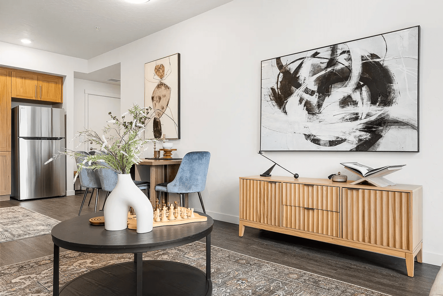 A modern living room with a large abstract painting on the wall.